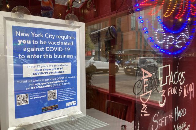 The sign outside a restaurant informing visitors they must be vaccinated to enter the business.